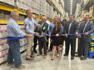 PCEDC President Kathleen Abels helps cut the ribbon at the opening of Restaurant Depot